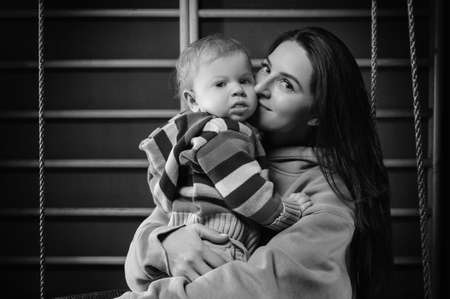 Young woman with little boy having fun on a swing. Entertainment parks concept. Mixed mediaの写真素材