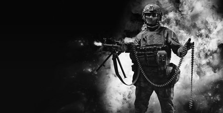Portrait of a fighter of a special unit. He lies on the ground and shoots from a heavy machine gun. SWAT concept. Mixed mediaの写真素材
