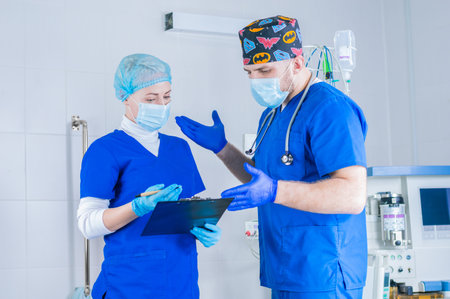 The male surgeon explains to the female anesthesiologist. And she makes notes on the tablet....
