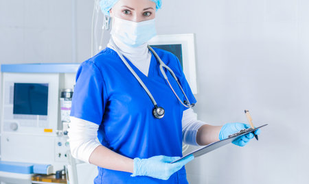 Portrait of a woman in a blue medical suit, mask and cap. Medicine concept. Mixed media