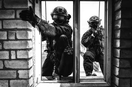 Group of special forces fighters storm the building through the window. Training sessions of the SWAT team. Anti-terror concept. Climbers. Mixed mediaの写真素材
