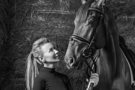 Stunning blonde posing with a thoroughbred horse. Ranch vacation concept. Mixed mediaの写真素材