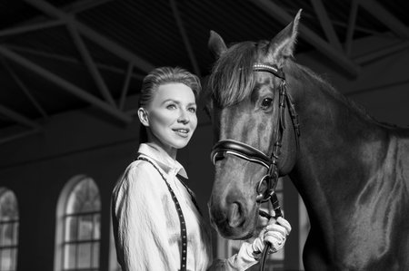 Portrait of a stylish woman hugging a thoroughbred horse. Love and care concept. Mixed media