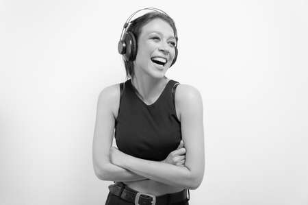 Portrait of a laughing woman in headphones. Musical accessories concept. Mixed mediaの写真素材