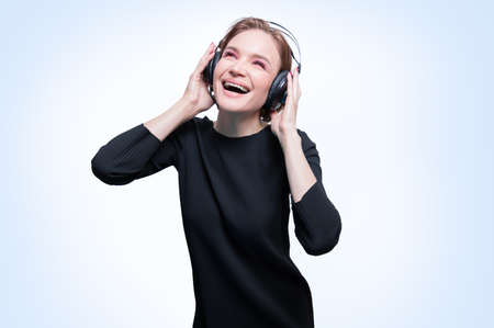 Portrait of a woman in professional headphones. White background. Dj concept. Mixed mediaの写真素材