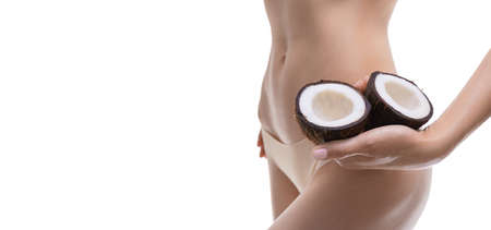 Image of a woman holding coconuts near her belly. Cosmetic concept. Mixed mediaの写真素材