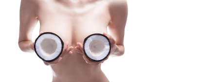 Image of a woman holding coconuts near her chest. Cosmetic concept. Mixed mediaの写真素材