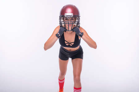 Woman in the uniform of an American football team player posing on a white background. Sports concept. Mixed mediaの写真素材