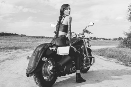 Young sexy girl posing on a motorcycle at sunset. Motor sport concept. Mixed media
