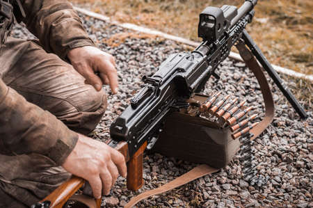 Image of a soldier equipping a heavy machine gun. The concept of military conflicts. Mixed mediaの写真素材