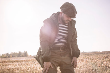 Image of a man putting on camouflage before hunting. Duck hunting season. Mixed media