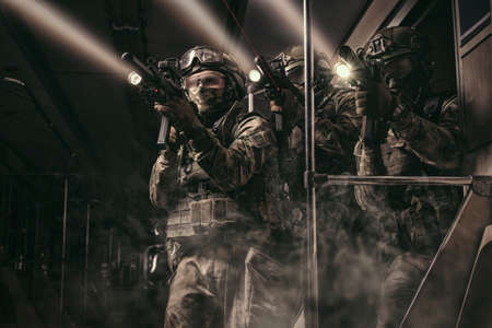Soldiers of a special anti-terrorist unit storm a railway carriage in the subway. Special operation concept. Mixed mediaの写真素材