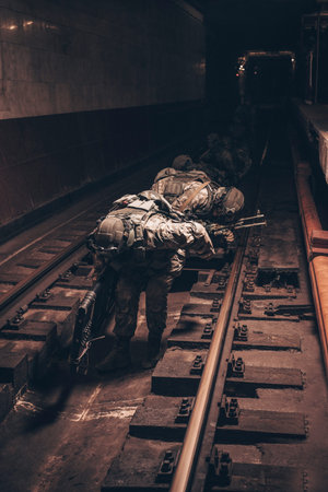 Image of a SWAT group sneaking along the rails in the subway. Special operation concept. Mixed media