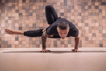 Adult man performs asana exercises. Yoga concept. Sports and healthy lifestyle. Mixed mediaの写真素材