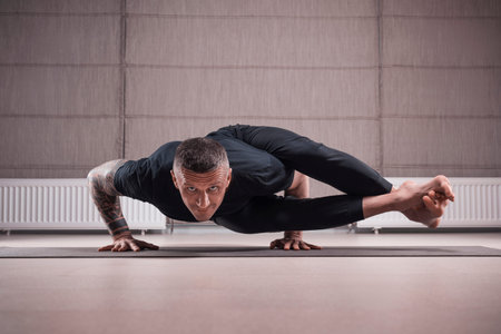 Adult man performs asana exercises. Yoga concept. Sports and healthy lifestyle. Mixed media