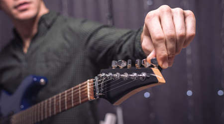 Image of a musician tuning a guitar. Concerts concept. Mixed mediaの写真素材
