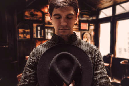 Portrait of a man holding his hat to his chest. Mafia style. Gangster Chicago. Mixed mediaの写真素材