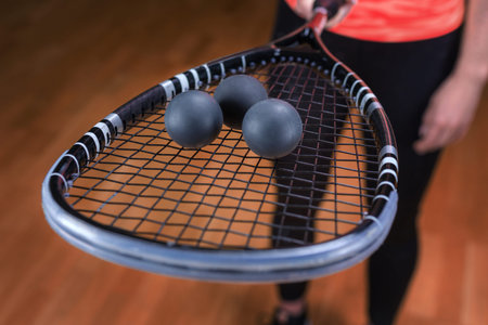 Image of racket and three squash balls. sports concept. mixed media