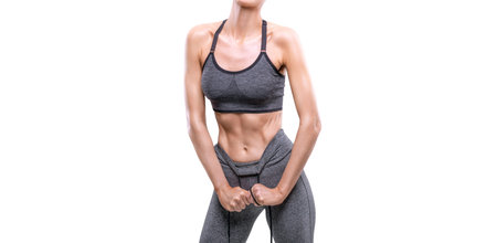 Image of an athletic girl with pumped abdominal muscles in a white studio. Fitness and bodybuilding...