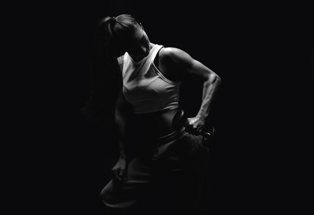 Athletic fitness woman posing in the studio on a dark background. Photo of an attractive woman in fashionable sportswear. Sports and healthy lifestyle. mixed mediaの写真素材