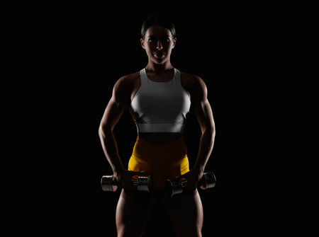 Brutal sports woman pumps up muscles with dumbbells. fitness concept. mixed mediaの写真素材