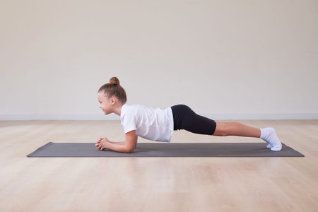 Little girl performs exercises in a gymnastics sports class. The concept of sports, Pilates, stretching, healthy lifestyle. Mixed mediaの写真素材