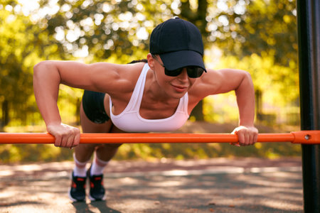 Beautiful young fitness girl is warming up at the stadium before training. Attractive slender...
