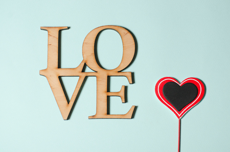 Word Love from a tree and a red heart to Valentine's Day lie on a turquoise backgroundの写真素材