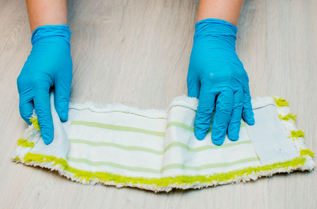Cleaning in the apartment. Female hands in blue rubber gloves. The concept of cleaning.の写真素材