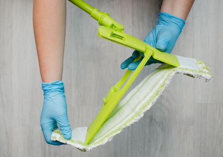 Cleaning in the apartment. Female hands in blue rubber gloves. Cleaning Conceptの写真素材