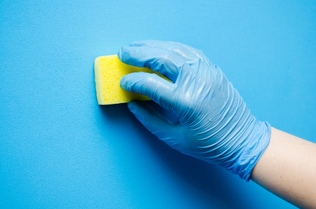 Cleaning in the apartment. Female hands in blue rubber gloves. Cleaning Conceptの写真素材