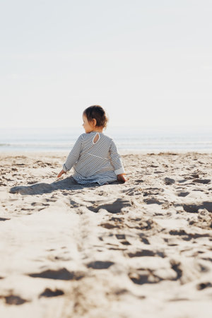 Serene Little Beach Dweller , A young girl in a peaceful moment,