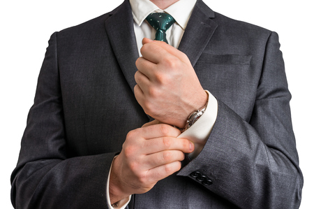 Business man fixing his cufflinks - isolated on white backgroundの写真素材