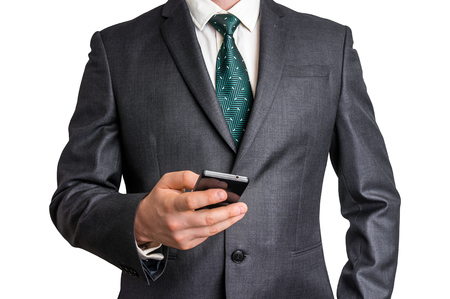 Businessman in black suit with mobile phone - isolated on white backgroundの写真素材