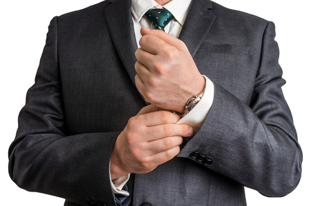 Business man fixing his cufflinks - isolated on white backgroundの写真素材