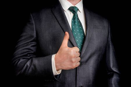 Businessman showing gesture with thumb up - isolated on black backgroundの写真素材
