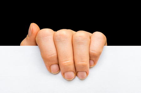 Woman's hand holding white blank paper isolated on black backgroundの写真素材