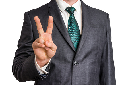 Businessman showing gesture victory with two fingers - isolated on white backgroundの写真素材