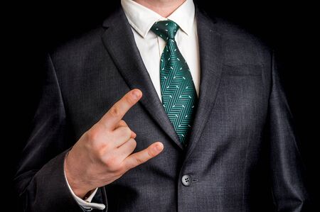 Businessman showing gesture with two fingers - isolated on black backgroundの写真素材