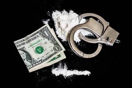 Handcuffs, money and cocaine drugs on black backgroundの写真素材