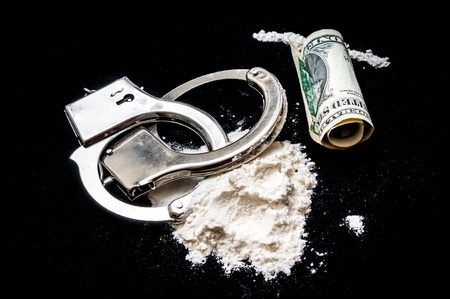 Handcuffs, money and cocaine drugs on black backgroundの写真素材