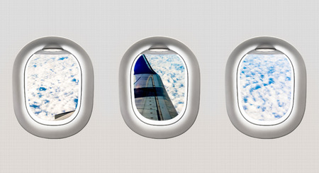 View of aircraft wing and clouds from airplane windows - flight conceptの写真素材