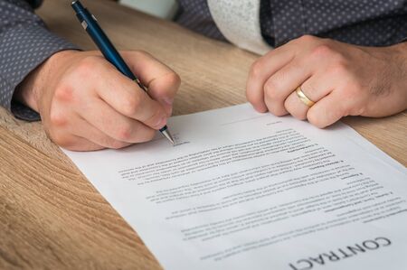 Businessman signing a contract to conclude a deal - business conceptの写真素材