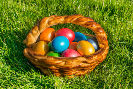 Colorful eggs in a basket on the green grass