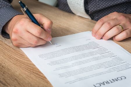 Businessman signing a contract to conclude a deal - business conceptの写真素材