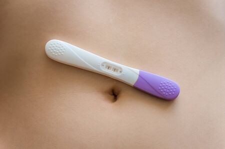 Pregnant woman and positive pregnancy test on bellyの写真素材