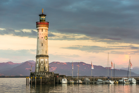 Beautiful evening seascape with lighthouse in harbor of Lindau in lake Constance, Germanyの写真素材