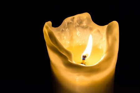One candle flame at night isolated on black backgroundの写真素材