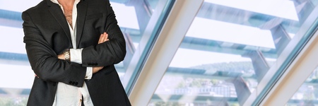 Disheveled man in business suit with folded hands in officeの写真素材