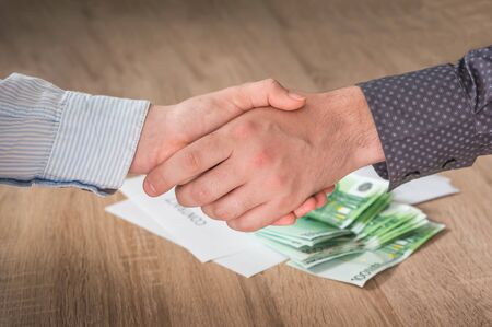 Business partners handshaking over successful conclusion of the business contractの写真素材
